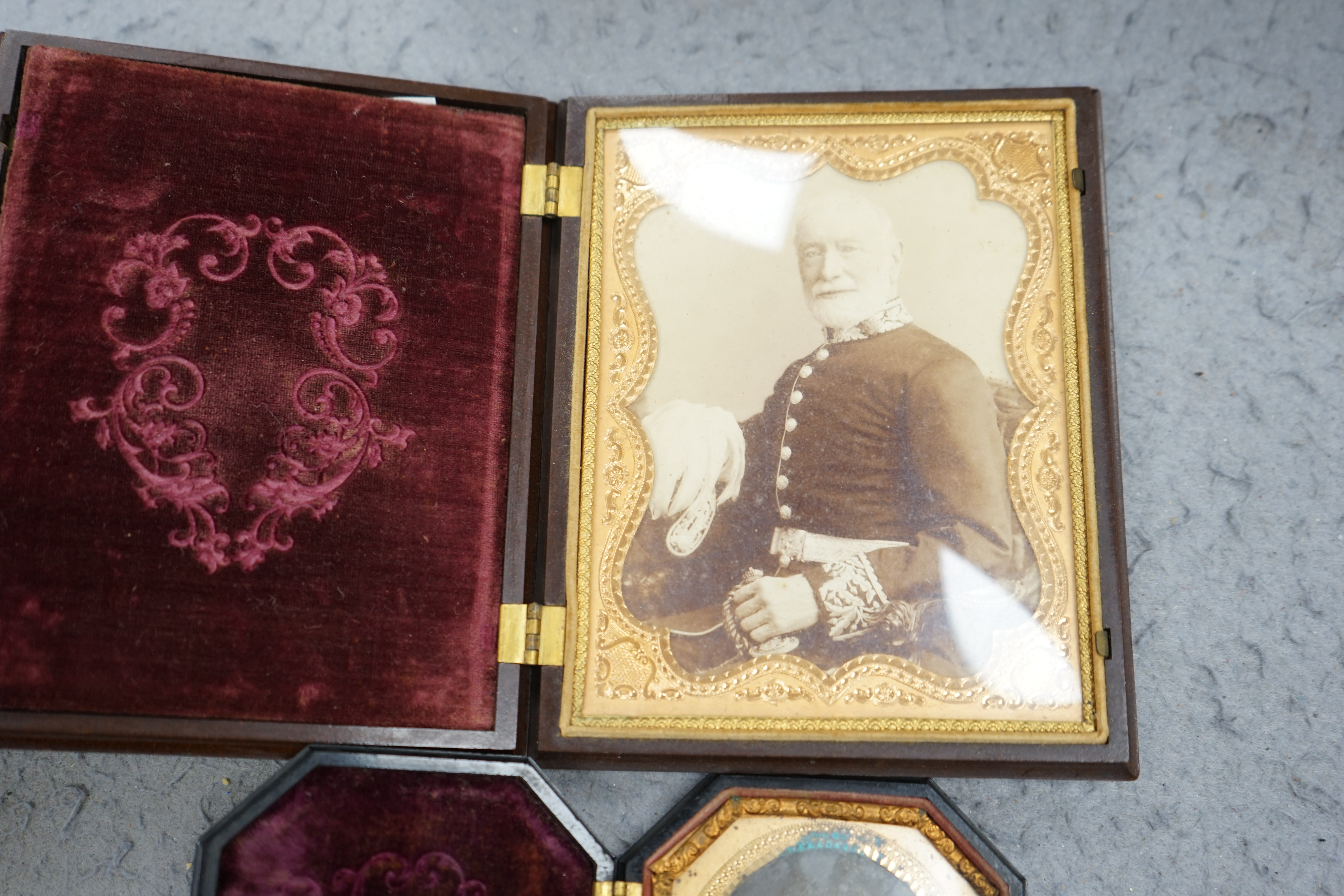 A pair of Peck & Co. sixth-plate ambrotype composite moulded cases, together with a Washington Monument phenolic cased ambrotype, largest 16 x 13cm. (3). Condition - fair